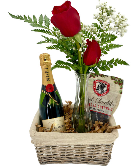 wine bottle, roses and chocolate in a wicker basket