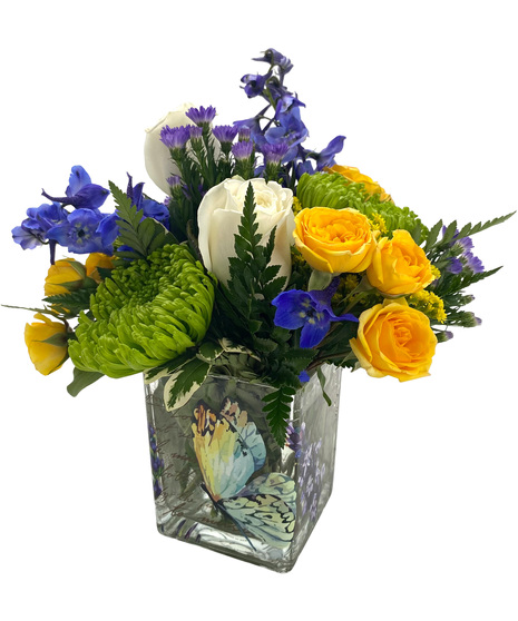 yellow, white and blue blooms in a glass cube with a butterfly on the side